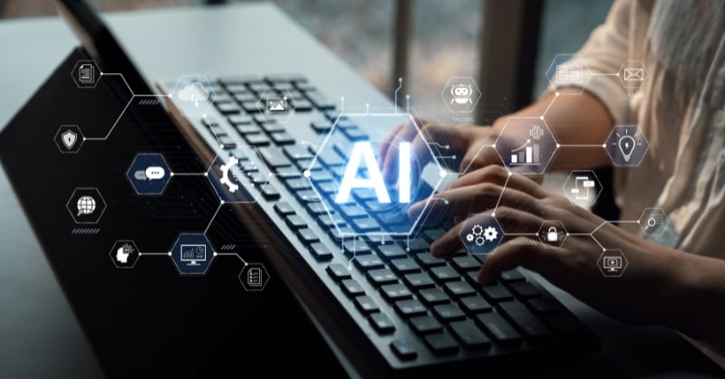 Person typing on a laptop with an AI graphic and digital technology icons overlaid on the screen.