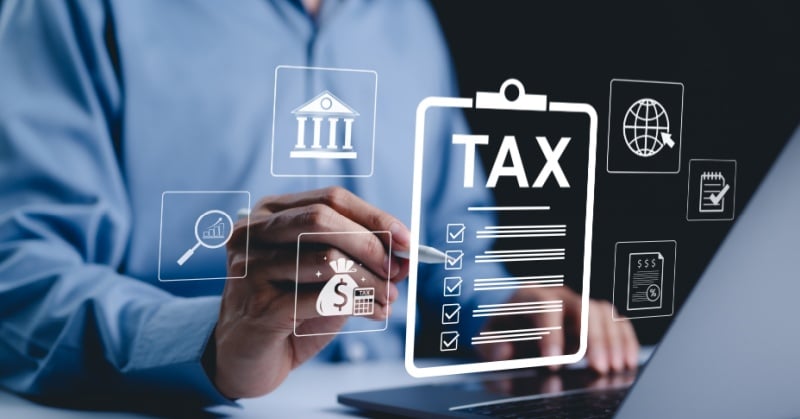 Person using laptop with digital tax icons, illustrating concepts of business tax compliance, nexus, and state tax obligations.