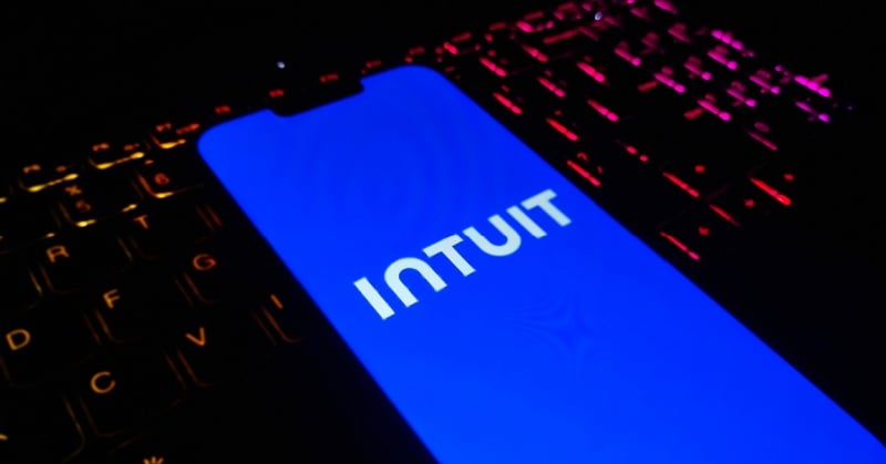 Smartphone displaying the Intuit logo on a dark keyboard with red and purple backlighting.