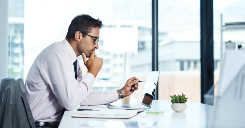 Business professional reviewing accounts payable information on a tablet in a modern office.