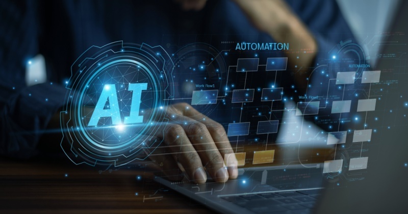 A person working on a laptop with digital overlays displaying the words "AI" and "Automation," representing artificial intelligence and workflow automation technology. 