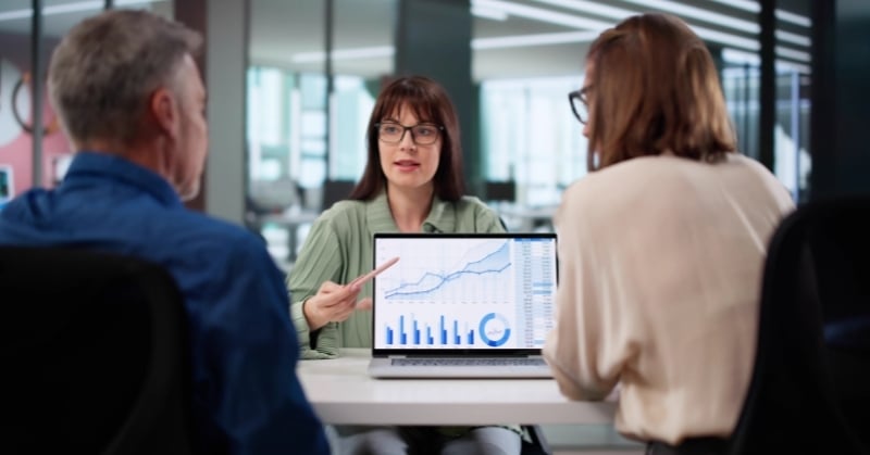 Advisor presenting a 13-week cash flow forecast with charts to clients during a financial planning meeting.