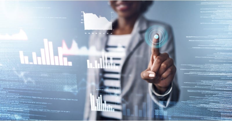 A business professional interacts with a digital interface, selecting data visualizations and analytics using touch-based technology.