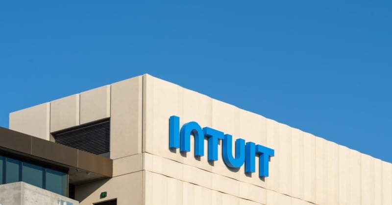 Exterior view of the Intuit corporate office building with blue sky background and Intuit logo prominently displayed.