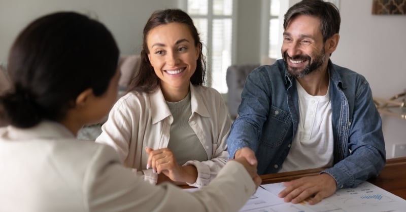Accounting professional shaking hands with prospective clients during a business meeting.