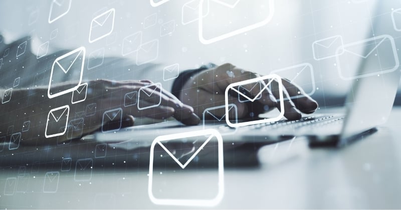 Digital email icons over a person typing on a laptop, representing automated client communication and personalized accounting firm messaging.