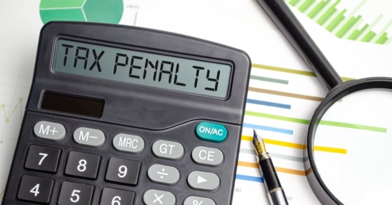 Tax penalty calculator with financial charts and a magnifying glass, illustrating IRS penalty relief and tax compliance monitoring.