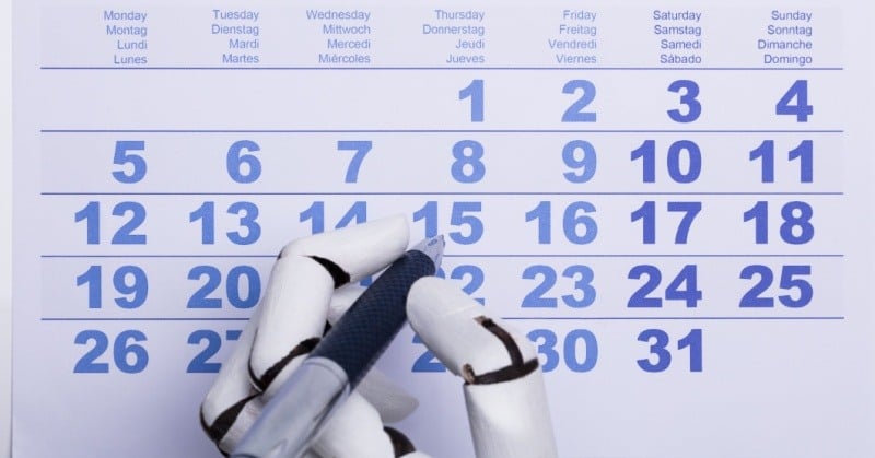 Robot hand writing on a paper calendar