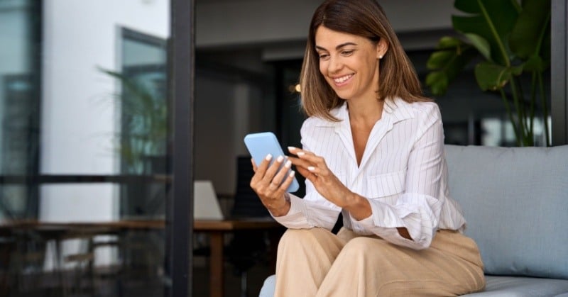 Professional woman texting on phone representing the new ways accountants are communicating with clients.