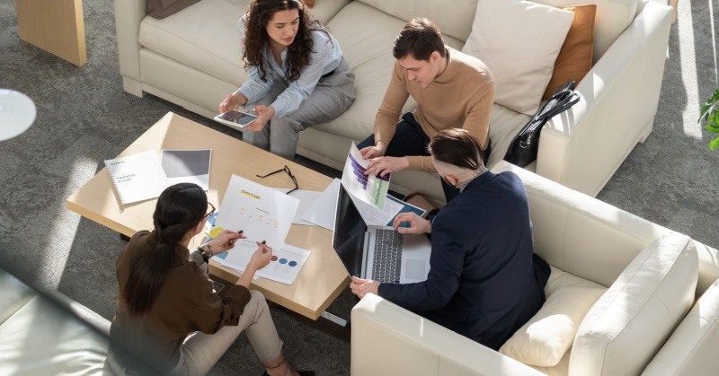 A diverse team of professionals analyzes data on multiple screens. 