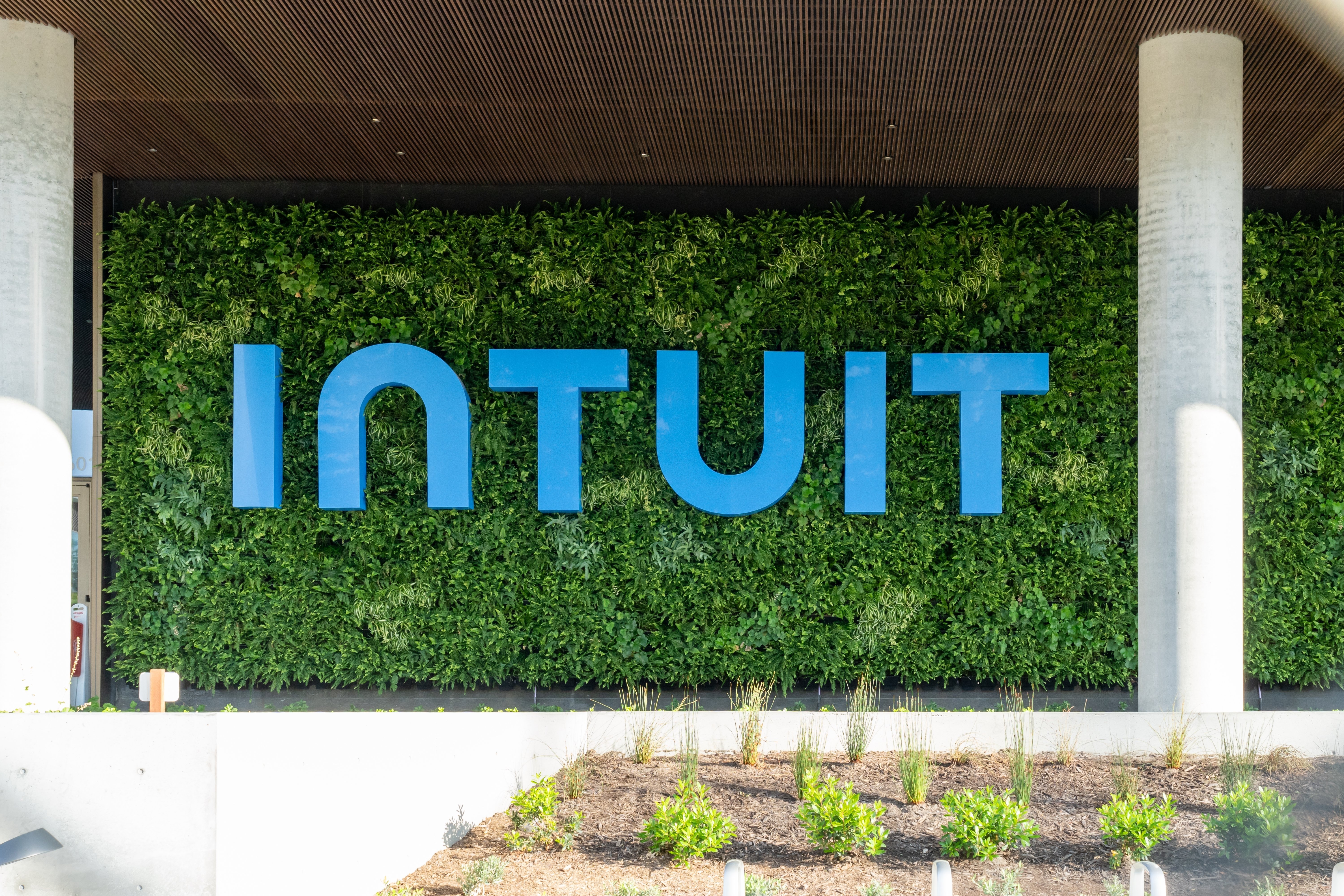 green wall of leaves big blue text that says intuit white stone floor with garden brown ceiling