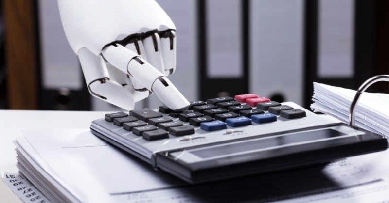 white robot hand typing on calculator on binder